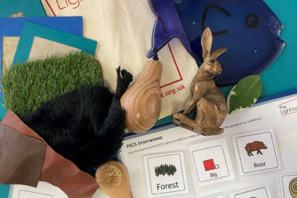 symbols choosing page and small handing objects including a wooden Hare with a bag with The Lightbox written on it.